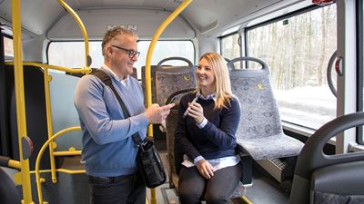 An inspector checks a woman’s ticket on her mobile phone.