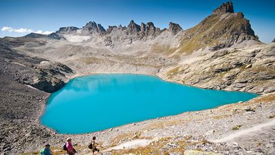 Hikers walk along the sky blue lake