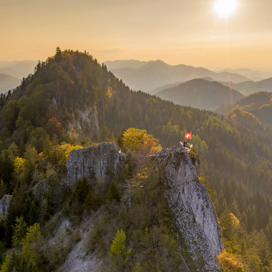 View of the Belchenflue mountain summit with the Swiss national flag in the Jura located in the Basel-Land area.
