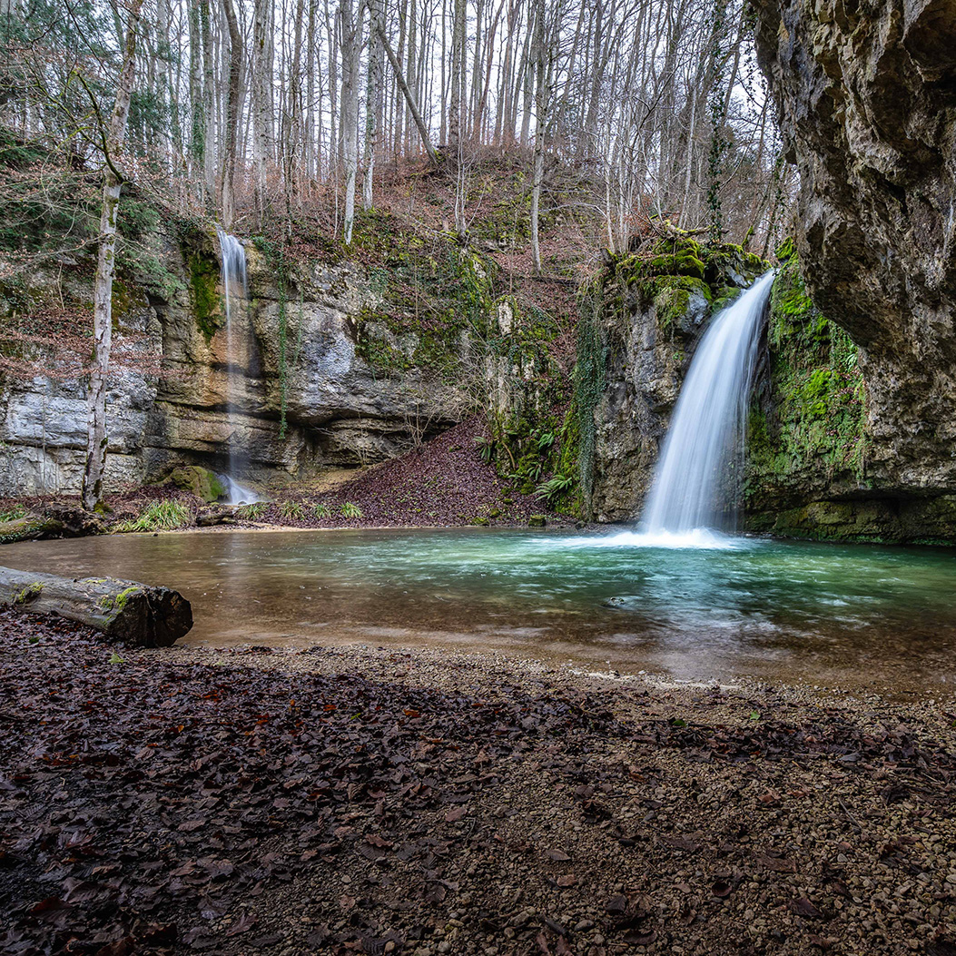 The “Rünenberger Giessen” waterfall pours over a curved rock face and into the depths.