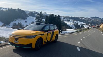 An automated electric car can be seen against a rural backdrop.