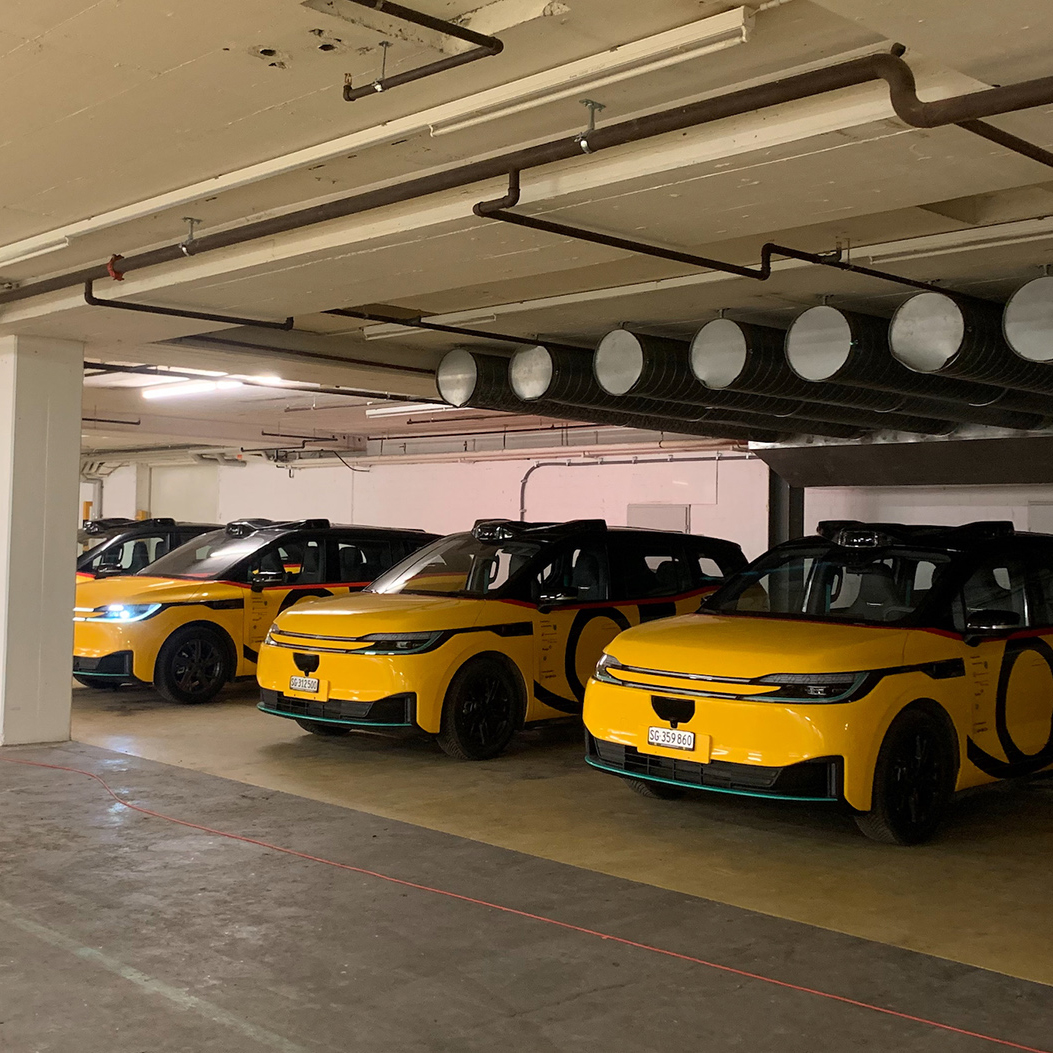 A number of AmiGo vehicles are parked in the underground car park of the depot.
