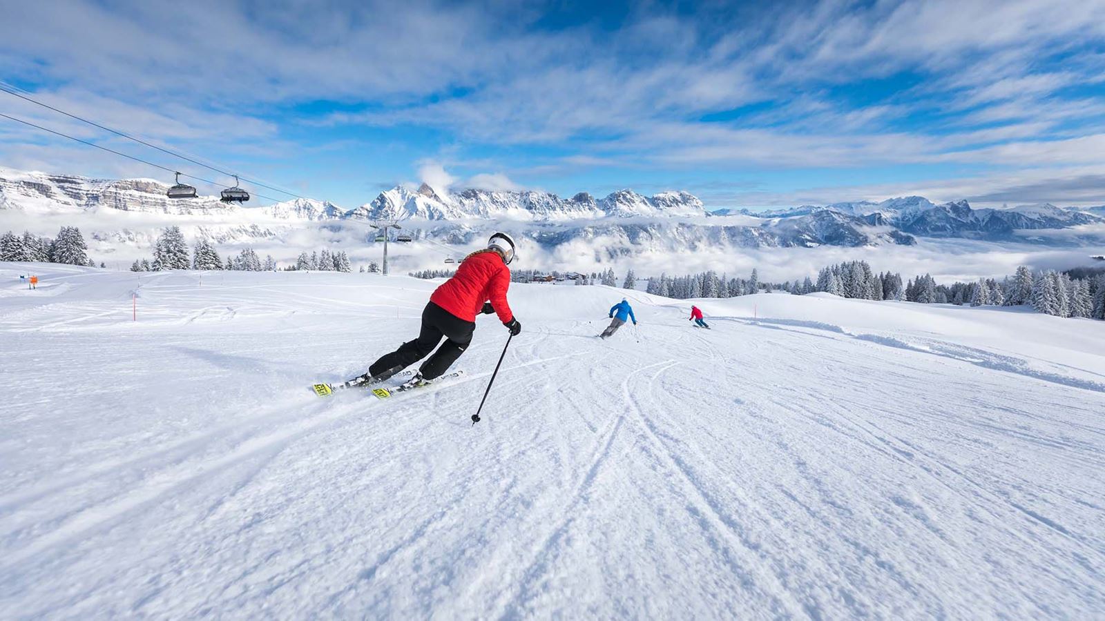 Skieuse dévalant une piste du domaine de Flumserberg par une belle journée d’hiver.